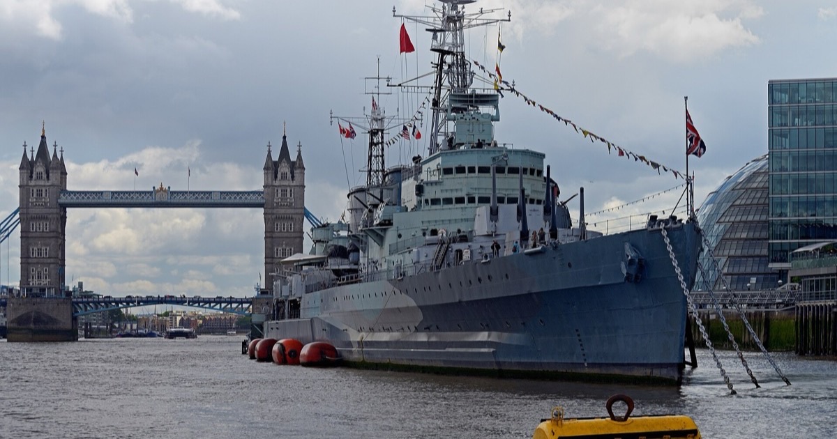HMS Belfast moored on the River Thames with Tower Bridge behind it, London